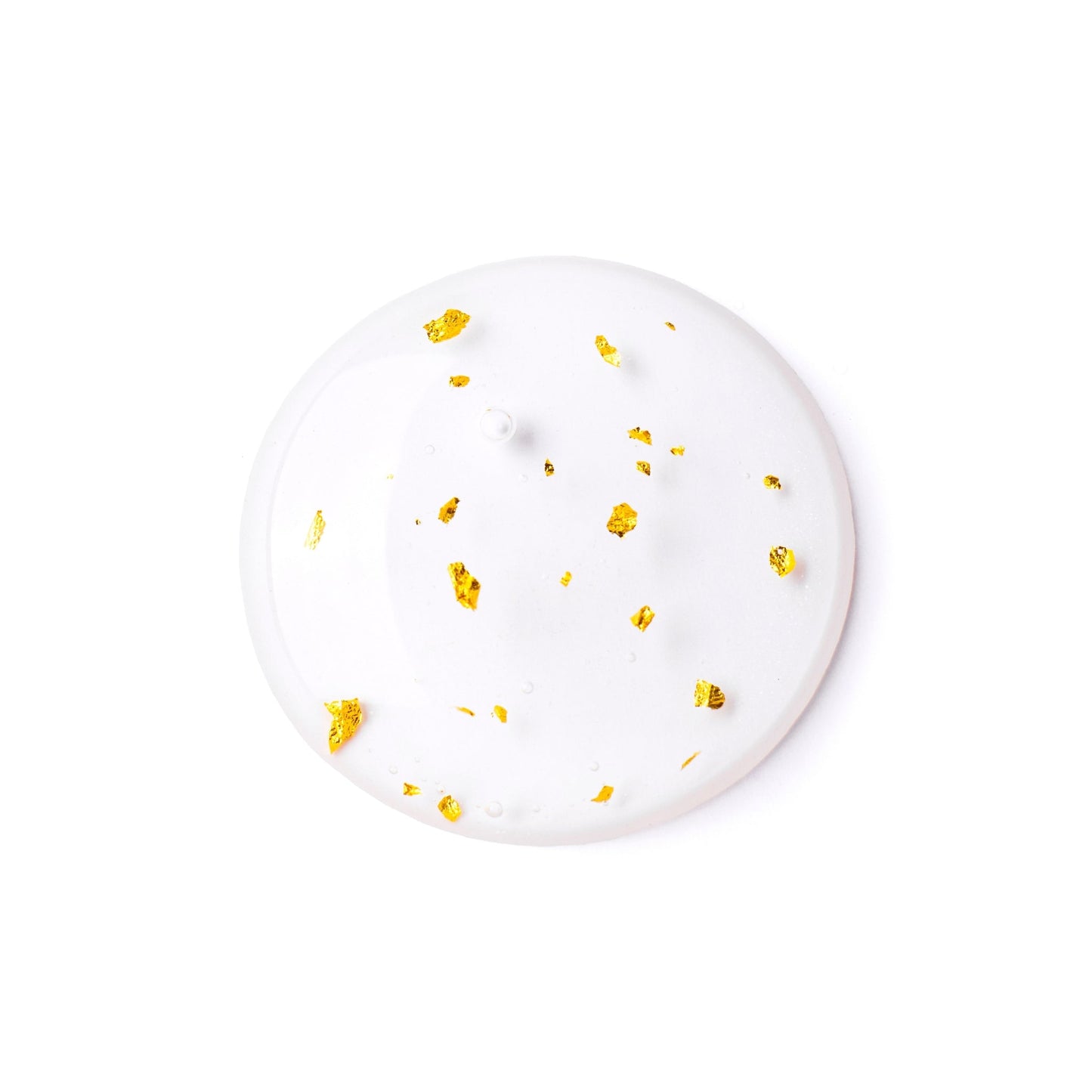 Close-up of a serum sample with flecks of gold, showcasing its luxurious texture.