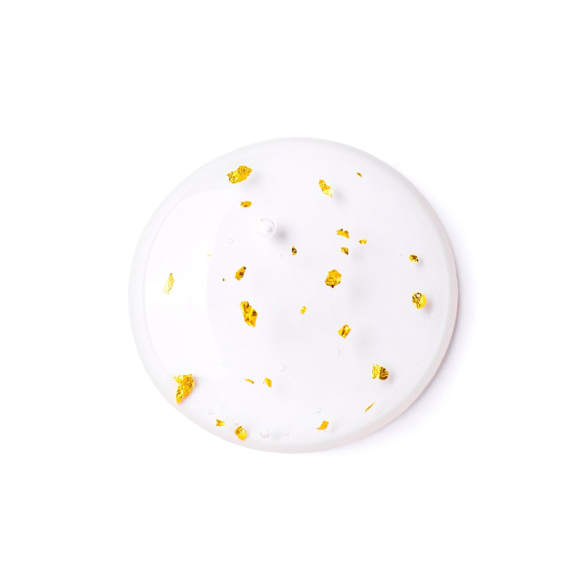 Close-up of a serum sample with flecks of gold, showcasing its luxurious texture.