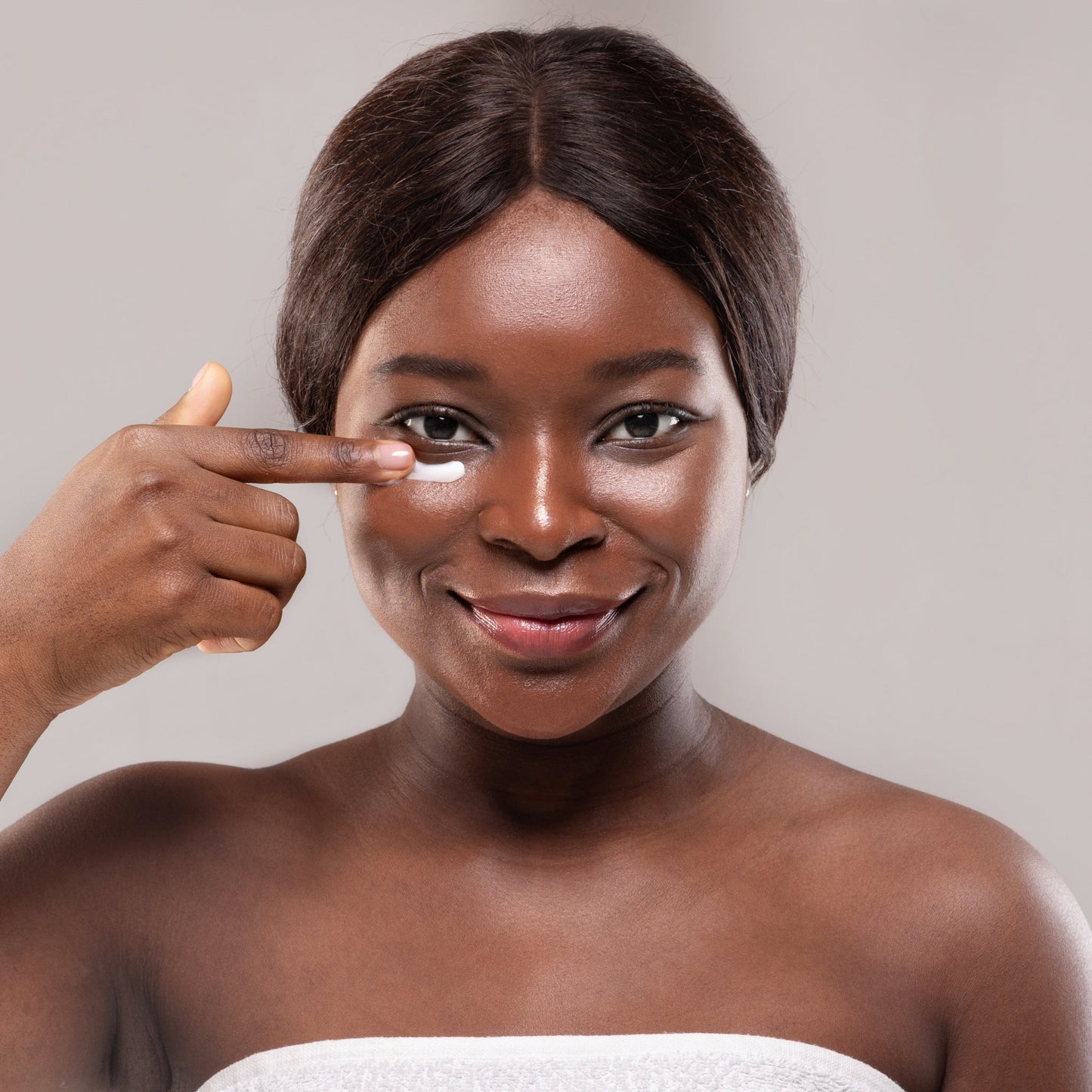 Woman applying hydrating eye cream under her eyes.
