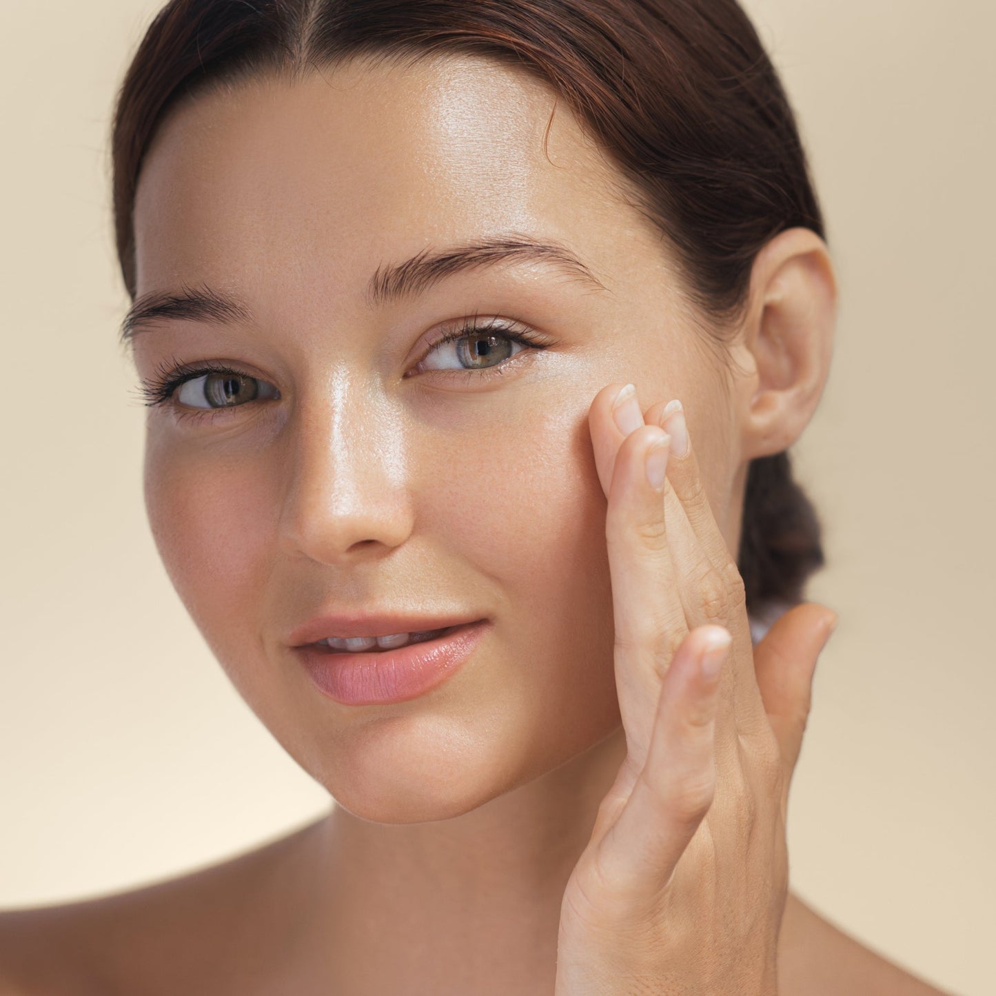 Woman applying hydrating face serum, showcasing radiant skin.