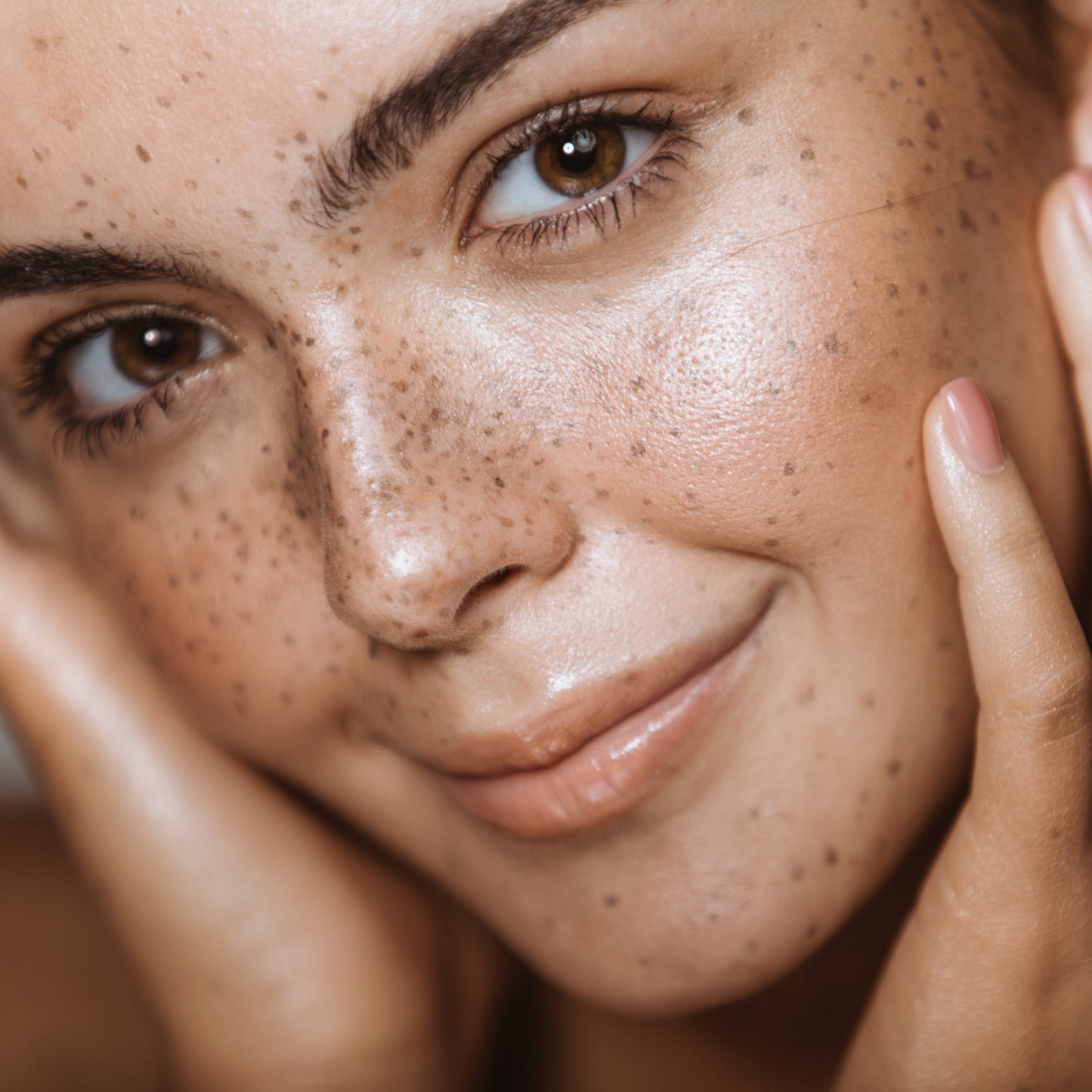Close-up of a freckled face, showcasing healthy, radiant skin.