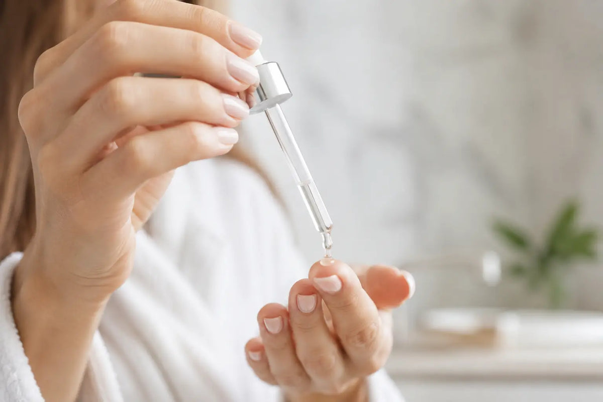 Applying niacinamide serum with a dropper as part of a skincare routine