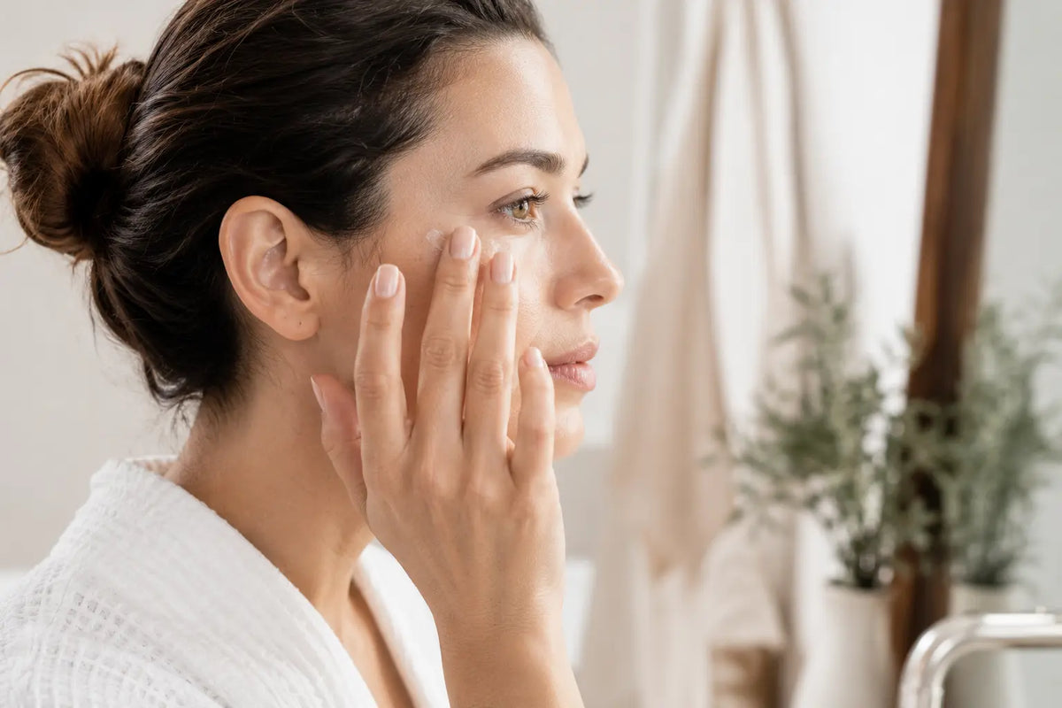 Woman applying caffeine eye cream to reduce the look of puffiness and tired eyes