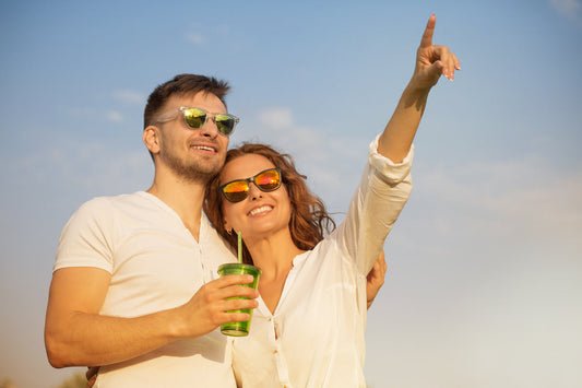Couple wearing sunglasses outdoors in sunny weather, enjoying time together with visible sun exposure, illustrating the need for powder sunscreen for convenient midday SPF touch-ups.