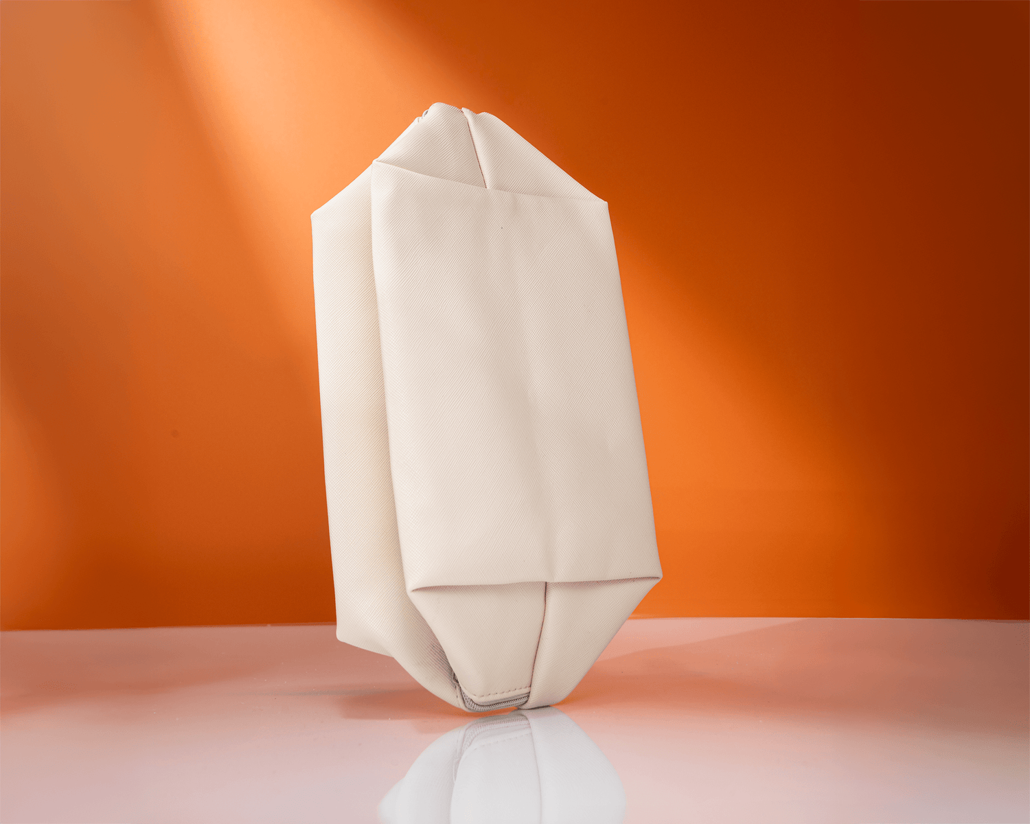 Vegan leather skincare organizer bag displayed against an orange background, featured as a free holiday skincare gift with purchase.